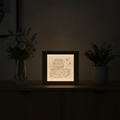 Decorative light box with honey theme on a dark surface with plants