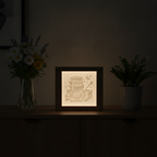Decorative light box with honey theme on a dark surface with plants